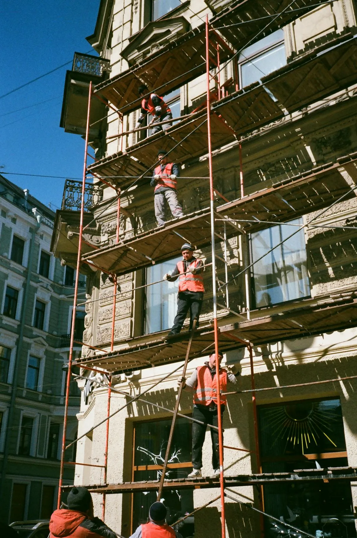 Trabajadores realizando montaje de andamio tubular en fachada de edificio